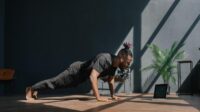 Pria melakukan push-up dengan posisi tubuh lurus dari kepala hingga tumit di atas matras latihan.